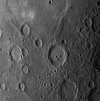 This image captures examples of the multiple processes that have played important roles in shaping the geology of Mercury's surface. Impact cratering has clearly been an influential process, and both old degraded craters and relatively young fresh craters can be spotted in this image. Near the center of the image is found a large, fresh crater with a smooth floor, central peak structures, terraced walls, and many associated small secondary craters. At the top of the image, smooth plains extend over a large area. There is evidence that many of the smooth plains are volcanic in origin. Wrinkle ridges are visible on the plains. In the lower left of this image, a scarp (cliff) cuts through a deformed impact crater.Such scarps are thought to be the surface expressions of large faults that formed in Mercury's past as the planet's interior cooled and the surface contracted slightly as a result.