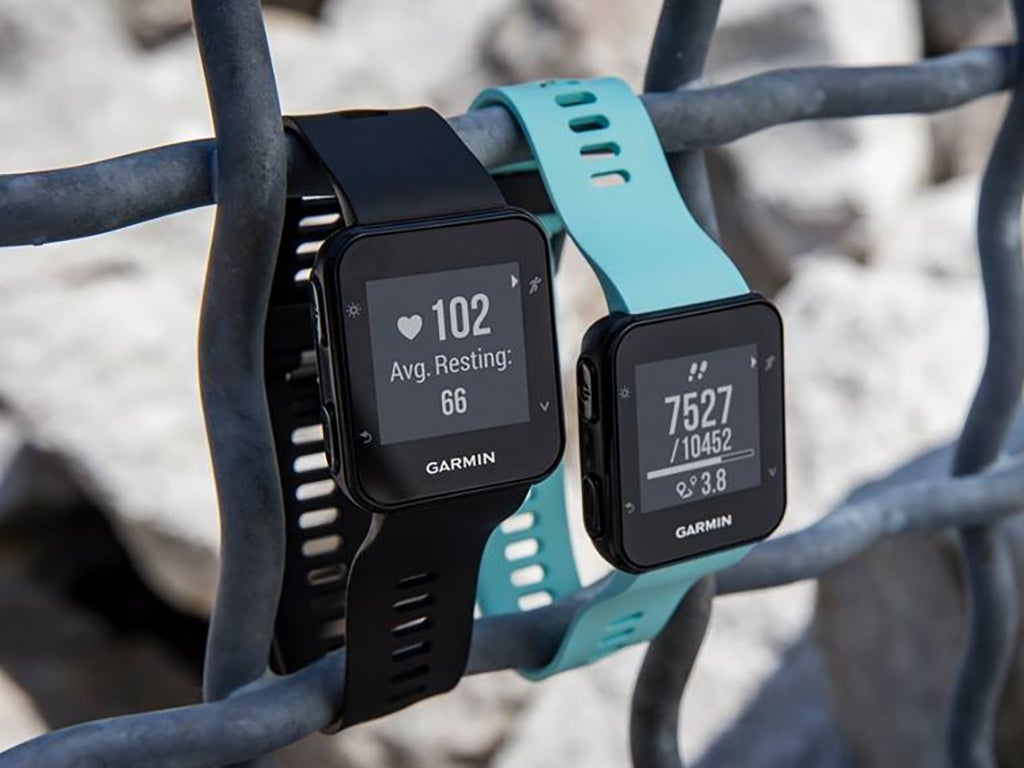 two Garmin Forerunner 35 fitness trackers on a fence