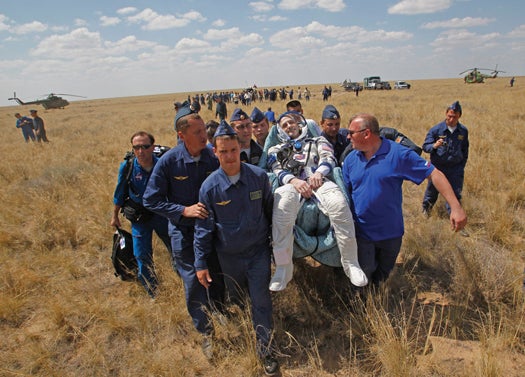 epa03291075 Russian space agency rescue team carry U.S. astronaut Donald Pettit (C) shortly after the landing of the Russian Soyuz TMA-03M space capsule at the south-east of the Kazakh town of Dzhezkazgan, Kazakhstan, 1 July 2012. The Soyuz capsule, which carried two astronauts and Russian cosmonaut safely returned to Earth on Sunday after a half-year stint on the international space station, with a landing on the Kazakh steppe. EPA/Mikhail Metzel POOL (Newscom TagID: epaphotos469106.jpg) [Photo via Newscom]