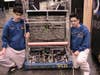 Two high school students with a homemade robot at the 2009 FIRST Robotics Competition in New York City.
