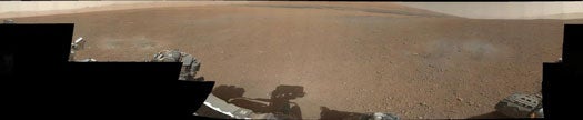 A 360-degree view of <em>Curiosity's</em> new home in Gale Crater. The two sets of dark, grey-ish spots in the left and right foreground were formed by blasts from the descent stage's rocket during landing.