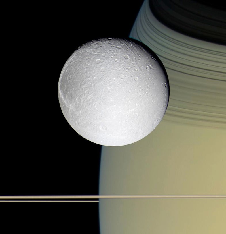 Icy Dione in front of Saturn. The horizontal stripes near the bottom of the image are Saturn's rings. Images taken on Oct. 11, 2005, with blue, green and infrared spectral filters were used to create this color view, which approximates the scene as it would appear to the human eye.