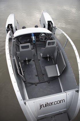 The cockpit of a homemade aluminum boat, in shallow water.