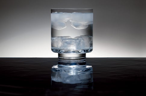 Heavy ice cubes at the bottom of a glass of water, and regular ice cubes floating on top.