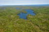 Aerial view of Sargent Lake surrounded by the forest of Isle Royale. Lake Superior in the distance.