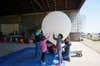 photo showing a family with children inflating a high-altitude balloon