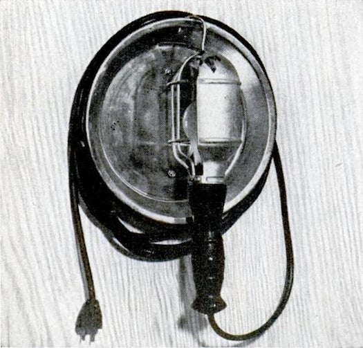trouble light mounted on a wall with a metal pan