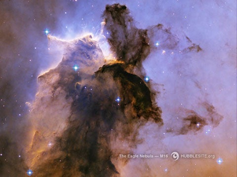 A billowing tower of gas and dust rises from the stellar nursery known as the Eagle Nebula. This small piece of the Eagle Nebula is 57 trillion miles long.