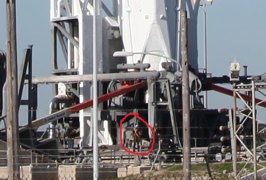 man standing next to rocket, zoomed out