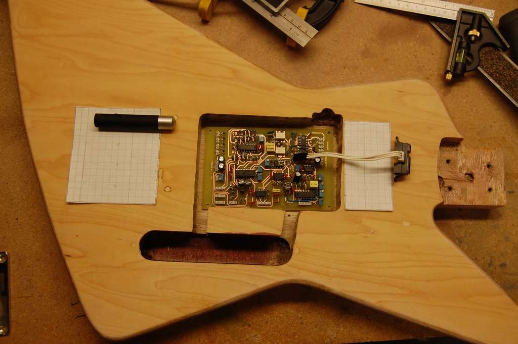 The body of an electric guitar with a circuit board inside it.