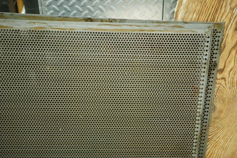 The perforated steel of the housing box for an arcade box.