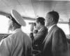 U.S. President Richard Milhous Nixon, holding binoculars, stands on board the U.S.S. Hornet aircraft carrier to watch Apollo 11's splashdown and recovery. On the right, slightly behind the president, is astronaut Frank Borman, the commander of Apollo 8.