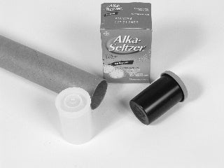 Two film canisters, a cardboard tube, and some Alka-Seltzer tablets. Grayscale.