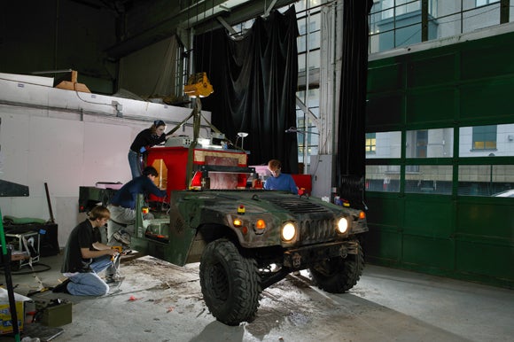 Here´s Red Team from Carnegie Mellon working on the first Hummer entry in the DARPA Grand Challenge. I really fell in love with the way that large black curtain draped in the background of this shot.