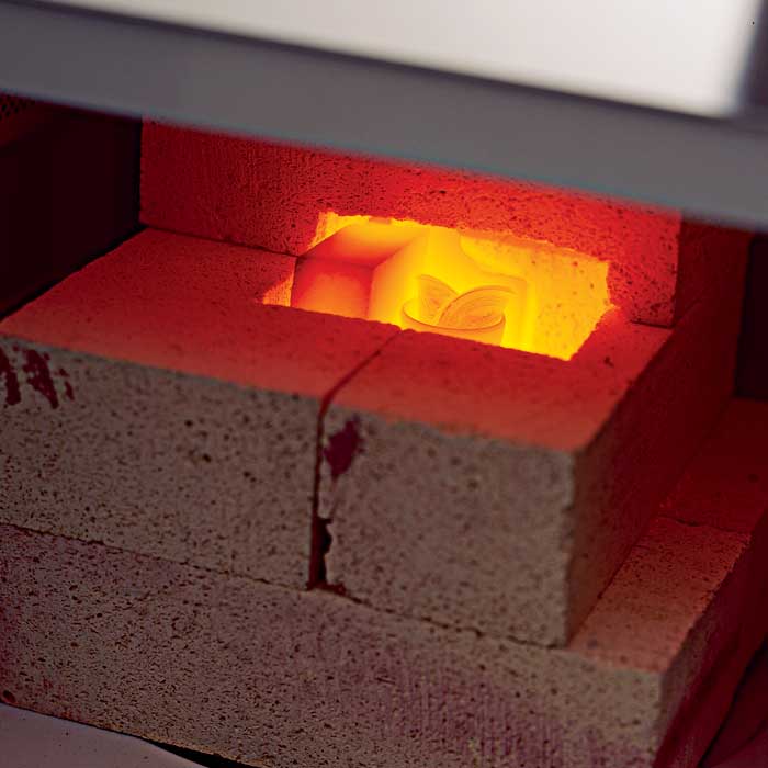 A firebrick-and-silicon-carbine furnace enclosure inside a microwave with red-hot silver inside it.