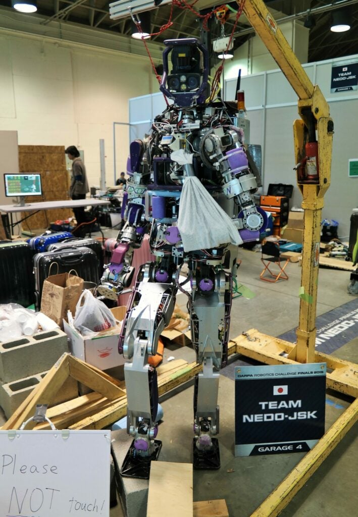 Jaxon humanoid robot in the DRC Team Garage with a sling on its arm