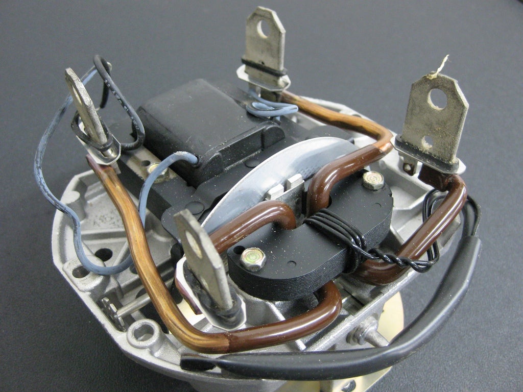 On the back of the meter are the electrical connections to the house's circuitry and the coils that drive the spinning aluminum wheel. The amount of current passing through these large conductors controls the speed of rotation of the wheel.