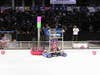 Two robots next to each other in an arena in front of a crowd at the 2009 FIRST Robotics Competition in New York City.