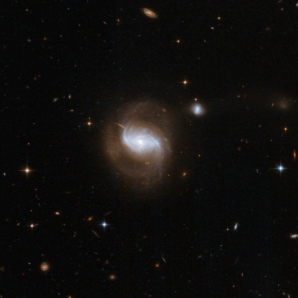IC 5298 is a beautiful face-on spiral galaxy with two long arms extending from the central bulge and curving back amongst the scattered stars, gas and dust. A nearby smaller companion is linked by a bridge of matter to the principal galaxy in an interaction reminiscent of the famous Whirlpool Galaxy, M51. There is also a third faint, irregular galaxy, visible at the top of the image that is also linked by a bridge of matter and probably involved in the interaction.