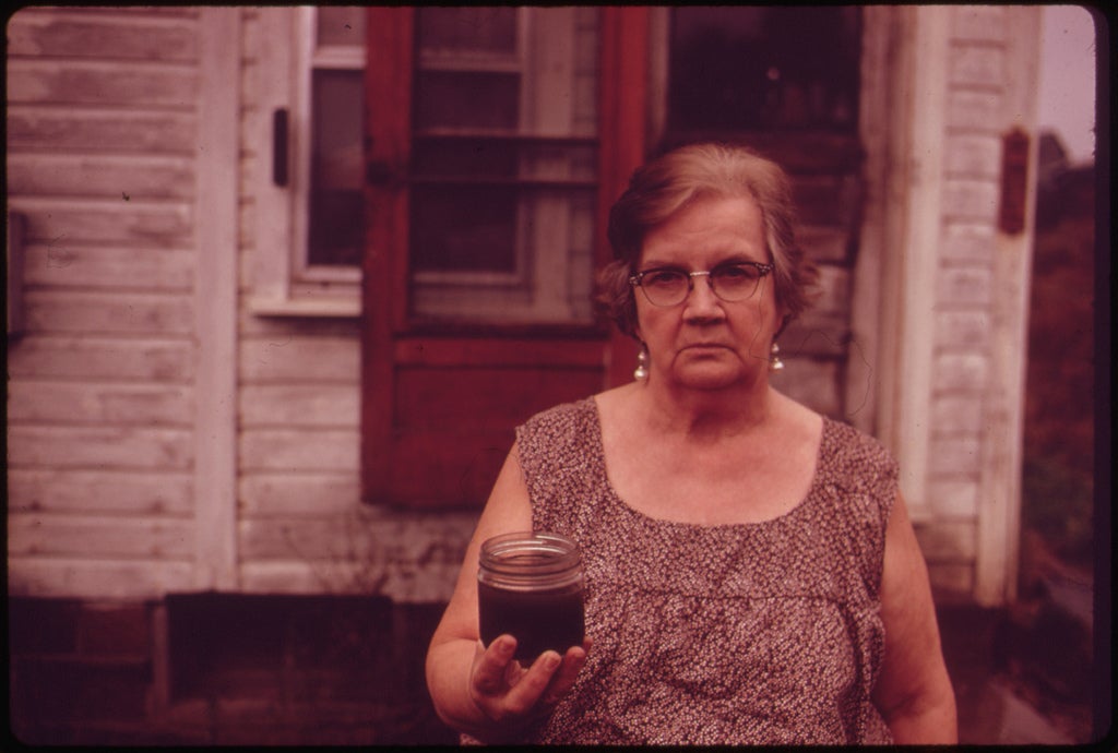 woman holding jar of tainted water