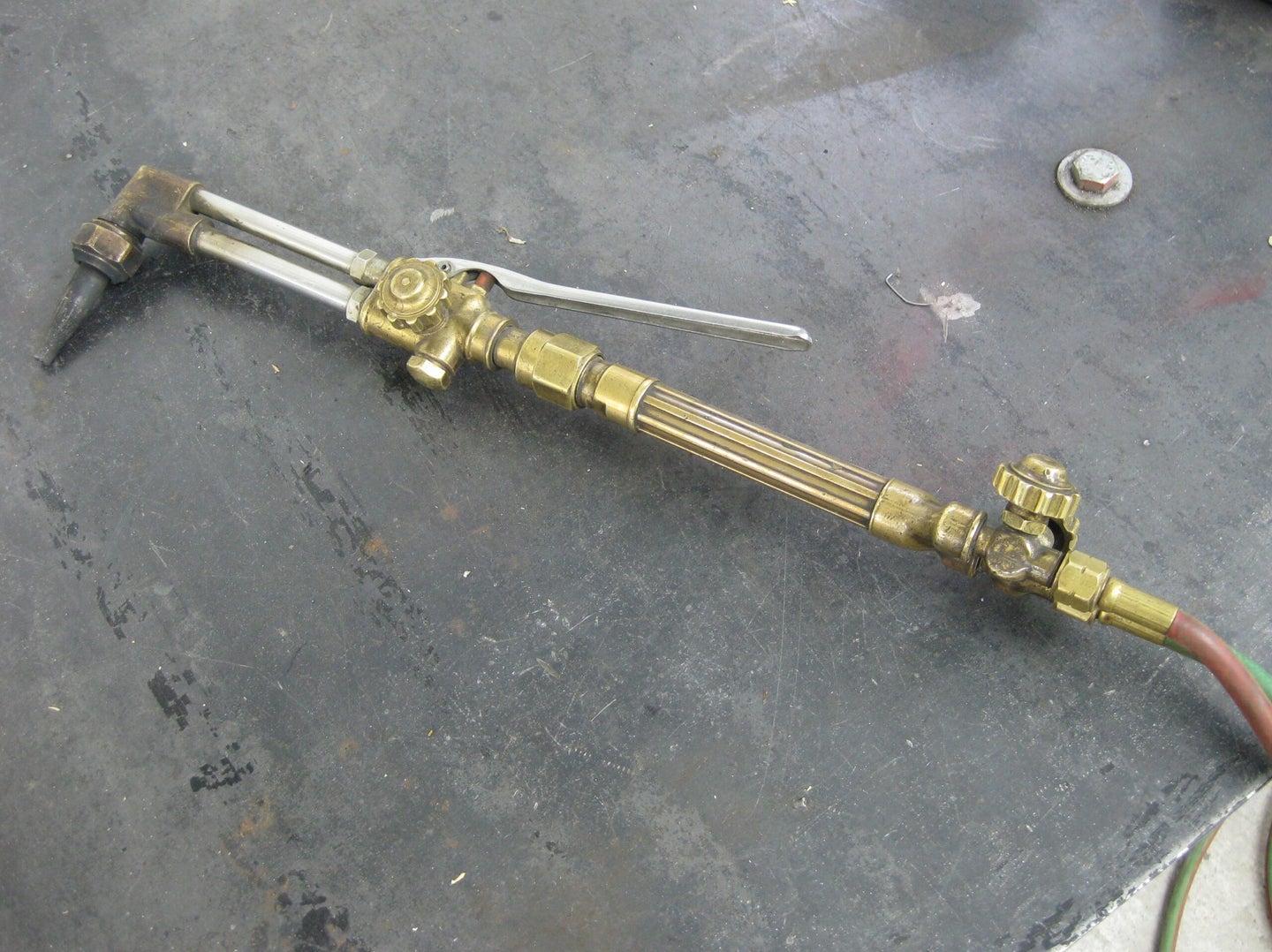 An inactive oxy-acetylene torch on a concrete floor.