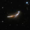 NGC 6670 is a gorgeous pair of overlapping edge-on galaxies resembling a leaping dolphin. Scientists believe that NGC 6670 has already experienced at least one close encounter and is now in the early stages of a second. The nuclei of the two galaxies are approximately 50,000 light-years apart. NGC 6670 glows in the infrared with more than a hundred billion times the luminosity of our Sun and is thought to be entering a starburst phase. The pair is located some 400 million light-years away from Earth.