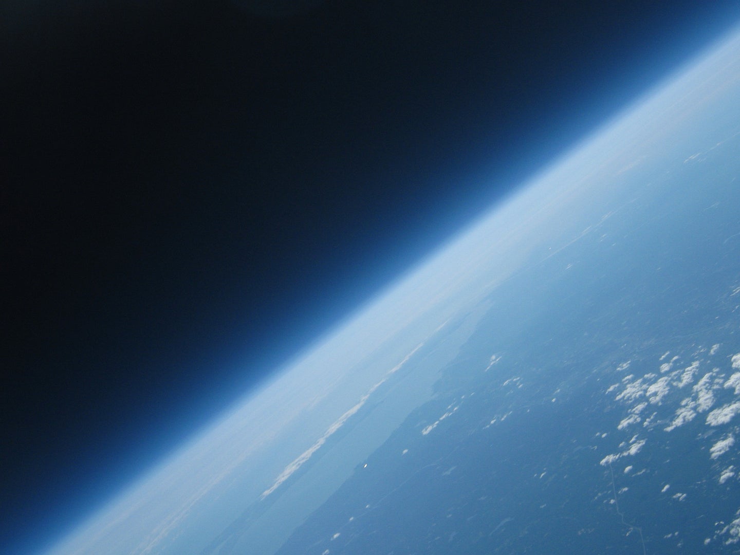 A portion of Earth, showing the boundary between space and the planet's atmosphere.