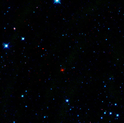 The red smudge at the center of this image is the first comet detected by WISE. Officially named "P/2010 B2 (WISE)," but known simply as WISE, the comet is a dusty mass of ice more than 1.2 miles in diameter that orbits the sun every 4.7 years.