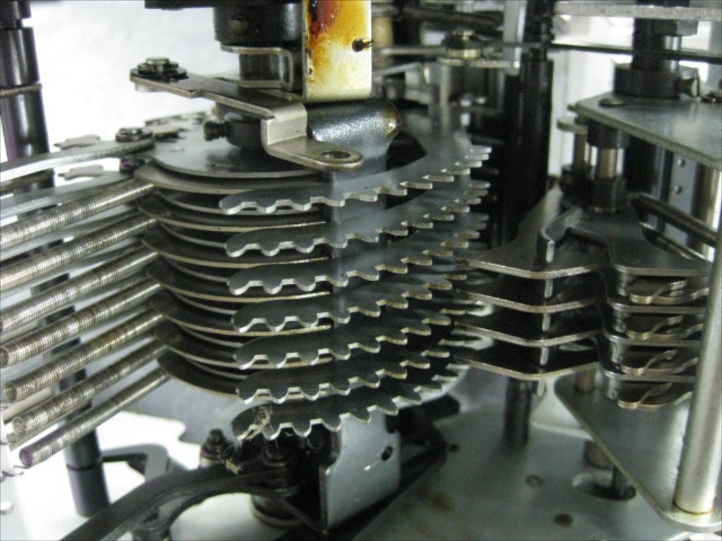 As the number bars of the previous picture retract back to their normal position (remember that the distance they moved, and therefore the distance they will retract, corresponds to a numerical value), they turn these "gears." These gears will turn from 0 to 9 positions, or teeth, depending on the number entered in the corresponding column of the keypad above. These teeth then engage the counter wheels - already removed in this picture - that we will see in the next few pictures.