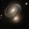 AM 0500-620 consists of a highly symmetric spiral galaxy seen nearly face-on and partially backlit by a background galaxy. The foreground spiral galaxy has a number of dust lanes between its arms. The background galaxy was earlier classified as an elliptical galaxy, but Hubble has now revealed a galaxy with dusty spiral arms and bright knots of stars. AM0500-620 is 350 million light-years away from Earth in the constellation of Dorado, the Swordfish.