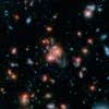 Astronomers recently announced that they <a href="http://iopscience.iop.org/article/10.1088/0004-637X/809/2/173;jsessionid=EFCC4C3758737C1EBEA3CB6ACFC41064.c1">found</a> a giant galaxy cluster with a hungry core (the bright blob at the center of this image) that's forming stars at breakneck speed. Their discovery is a rare one because galaxies at the centers of clusters are usually made of old or dead stars. The galaxy at the center of cluster SpARCS1049+56, however, is gobbling up gas from other galaxies and churning out stars at a rate of 800 new stars each year. To put that into perspective, the Milky Way forms two stars a year at most.