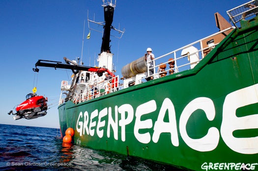 A crane onboard the <em>Arctic Sunrise</em> lowers researchers Steve Ross and John Hocevar into the Gulf of Mexico in the Dual DeepWorker 3 submarine.
