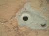 At the center of this image from NASA's Curiosity rover is the hole in a rock called "John Klein" where the rover conducted its first sample drilling on Mars. The drilling took place Feb. 8, or Sol 182, Curiosity's 182nd Martian day of operations.