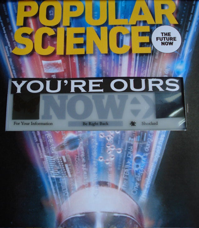 A Popular Science magazine cover with a hacked Esquire e-ink cover panel inside it, so the title reads "You're ours now :)".