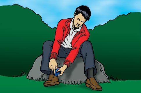 A man in a red jacket, a white collared shirt, and jeans, putting a battery into a shoe-mounted device charger.