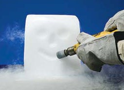 A person carving a smiley face into a block of dry ice.