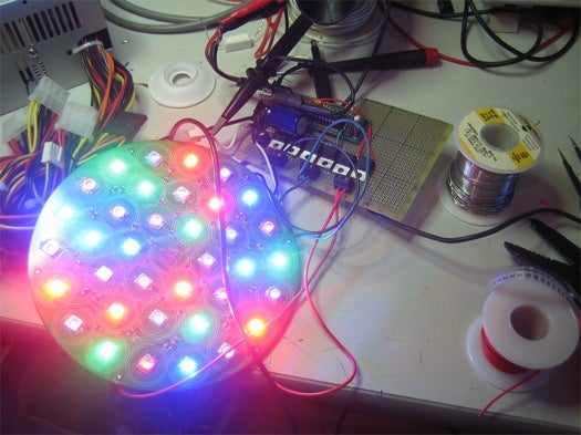 An open-source "bedazzler" with multiple multi-colored LEDs shining toward the camera.
