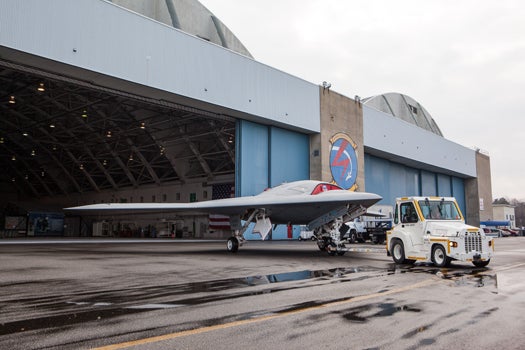 Vehicle pulling the X-47B out of the aircraft hangar