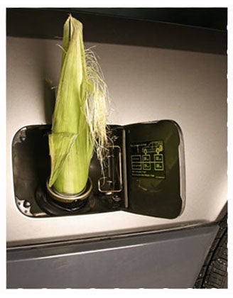 A car gas tank with an ear of corn stuffed into it.