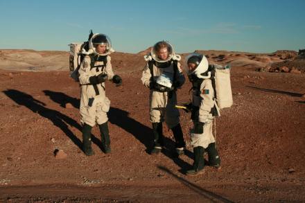 Crew members (left to right) Mary Beth Wilhelm, Clara McCrossin, and Raechel Harnoto check their GPS coordinates to be sure they've covered all the sites scheduled for geologic sample collection and radio to "HabCom" that they're ready to return to Hab.