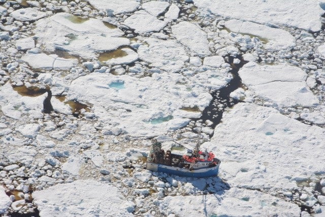 fishing boat surrounded by sea ice