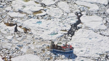 fishing boat surrounded by sea ice