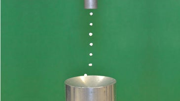photo showing an acoustic levitator levitating seven Styrofoam bits in a column