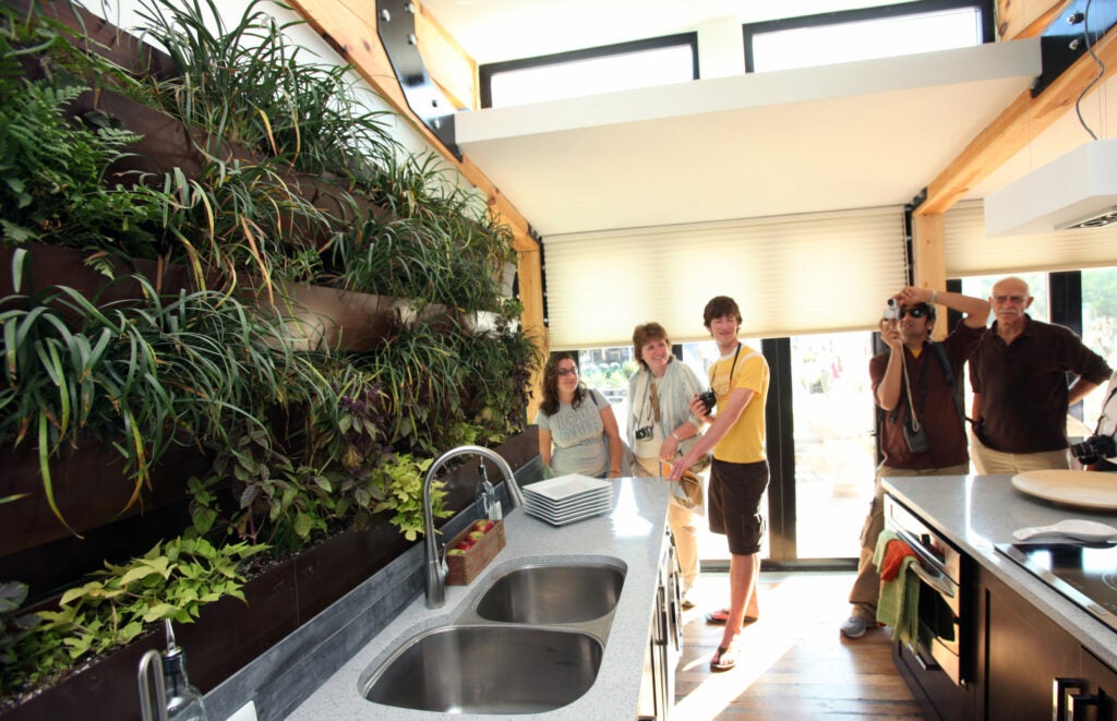 While some teams used plants to help filter their water, the Penn State and Rice University teams took the term living green to a whole new level. Penn State's kitchen features a wall of live herbs in the kitchen, convenient for cooks and for water filtration, and its roof features an array of plants among the PV panels, in an effort to keep things cool. Rice University turned that concept on its side, using a wall of greenery to cool their ZEROW house and unite it with the outdoors. In this photo, visitors check out the herb wall in Penn State's Natural Fusion home.