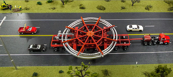 A model of the truck that will be used to transport the Muon g-2 ring, placed on a streetscape for scale. The truck will be escorted by police and other vehicles when it moves from Brookhaven National Laboratory in New York to a barge, and then from the barge to Fermi National Accelerator Laboratory in Illinois.