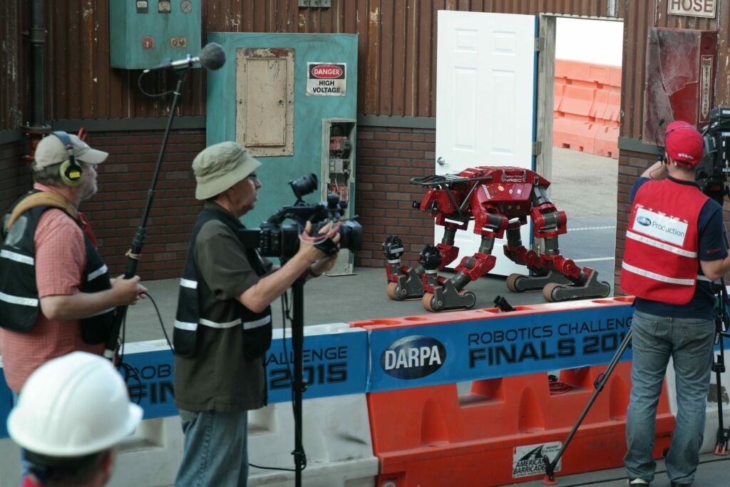 CHIMP humanoid robot recovers at the DRC with photographers around it