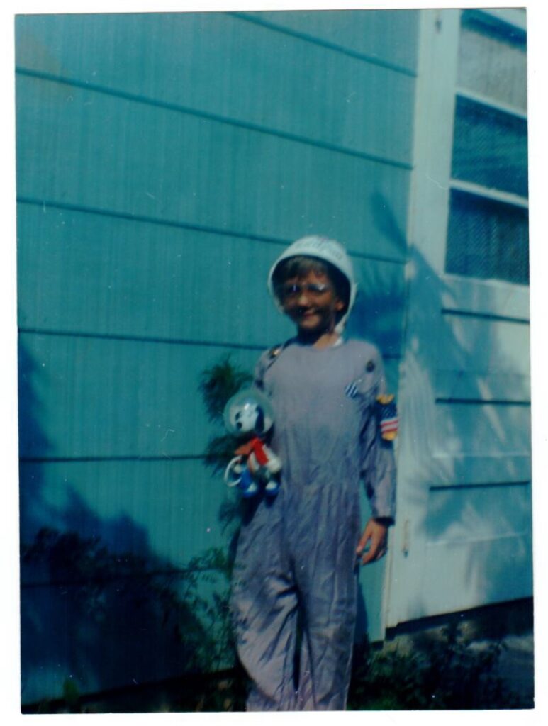 Child in a DIY astronaut suit with its Snoopy toy