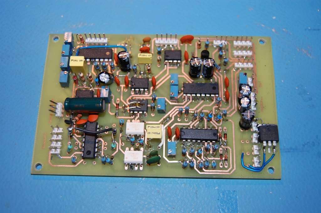 A printed circuit board on a blue surface.