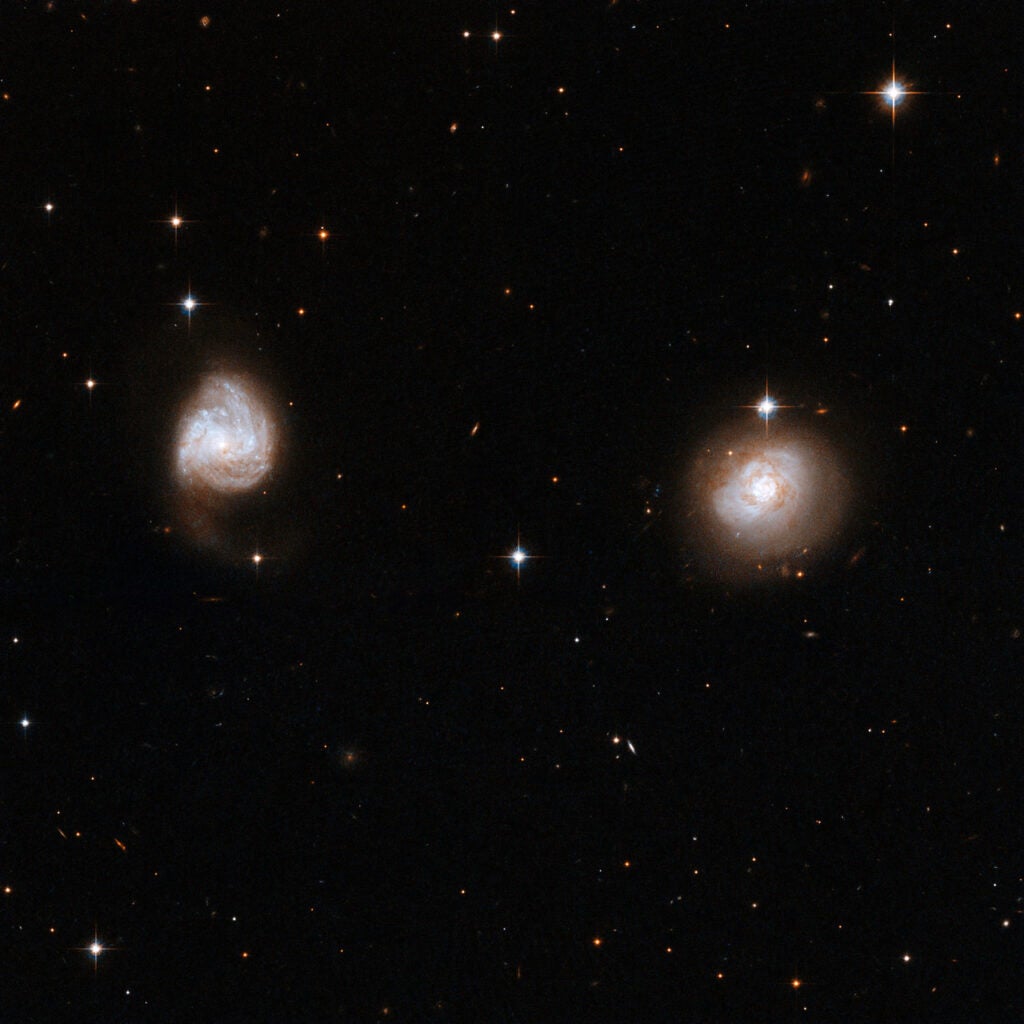 AM 0702 consists of a couple of detached galaxies, far apart and probably only just beginning to interact. The first signs of the interaction are visible in the galaxy on the left, where the outer structure of the spiral arms is starting to expand, extending a tidal tail of matter out into space.