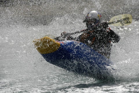 Shaun Baker riding in his jet ski-powered kayak, surround by a spray of water.